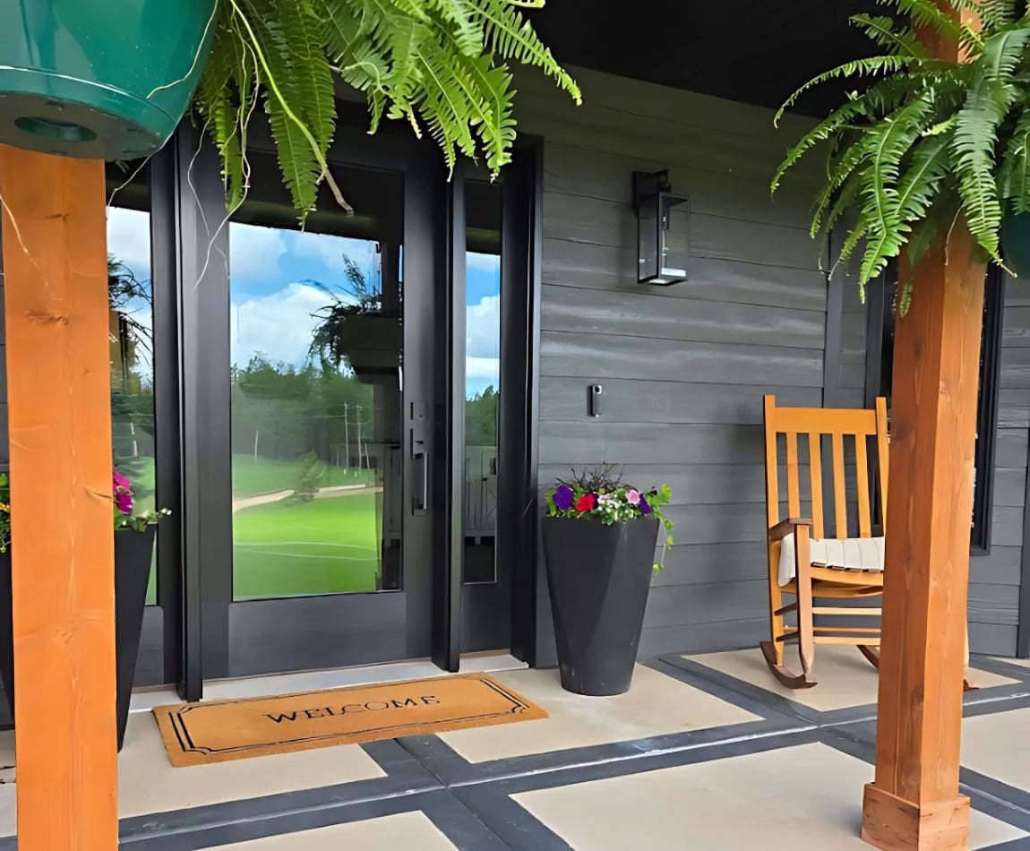 Front porch of a residential home with a wall-mounted security camera above the door, providing surveillance coverage for the entryway.