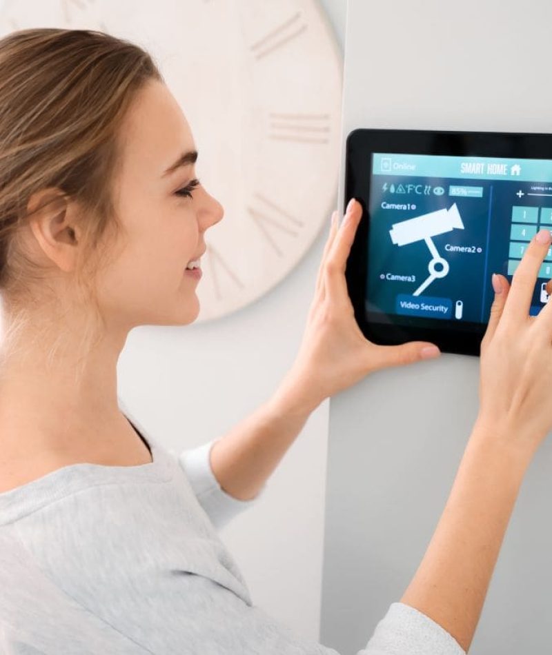 Woman setting up video security for her house using smart home technology