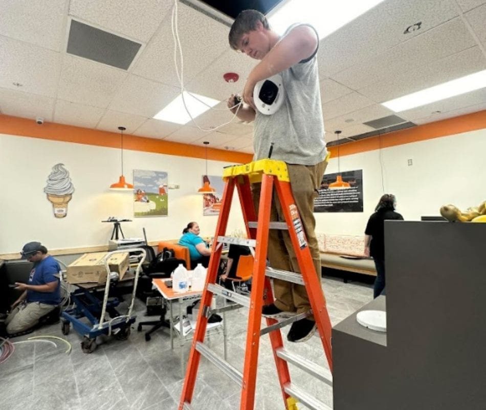 SoDak Technologies worker installing audio system at commercial property